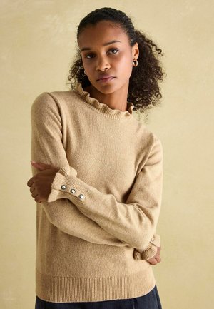 Beiger Pullover aus weichem Material. Mit geripptem Halsausschnitt und Bündchen sowie Knopfakzenten. Schlichtes Design mit lockerer Passform.