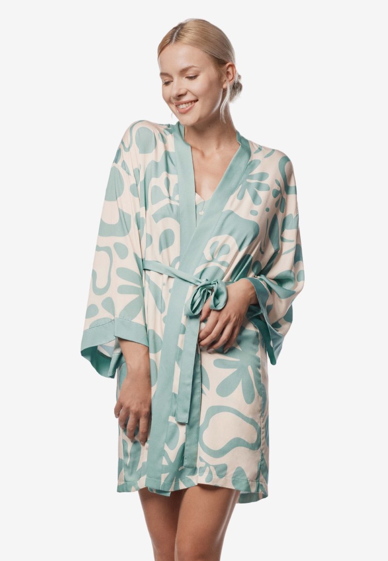 Jedwabny szlafrok w jasnym kremowym kolorze z dużymi turkusowymi abstrakcyjnymi wzorami, szerokimi rękawami, paskiem do zawiązania oraz luźnym krojem.