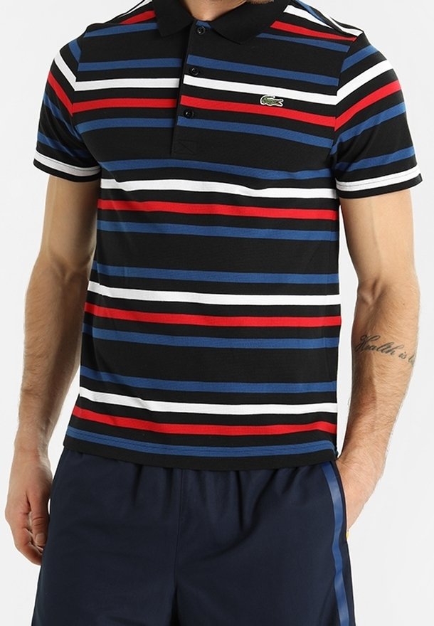 Polo rayé présentant des bandes noires, bleues, rouges et blanches, avec un col et un plastron à trois boutons ; logo Lacoste sur la poitrine.