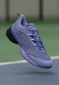 Chaussure de sport violette avec une tige en mesh texturé, semelle en caoutchouc et accents de marque subtils. Design léger avec une semelle intermédiaire rembourrée.