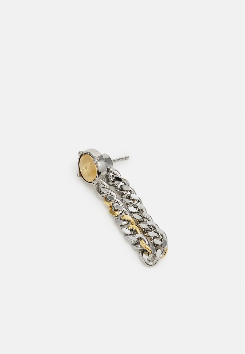 Boucle d'oreille goutte en chaîne métal mixte argent et or, avec un clou circulaire et une fermeture à tige sur fond blanc.
