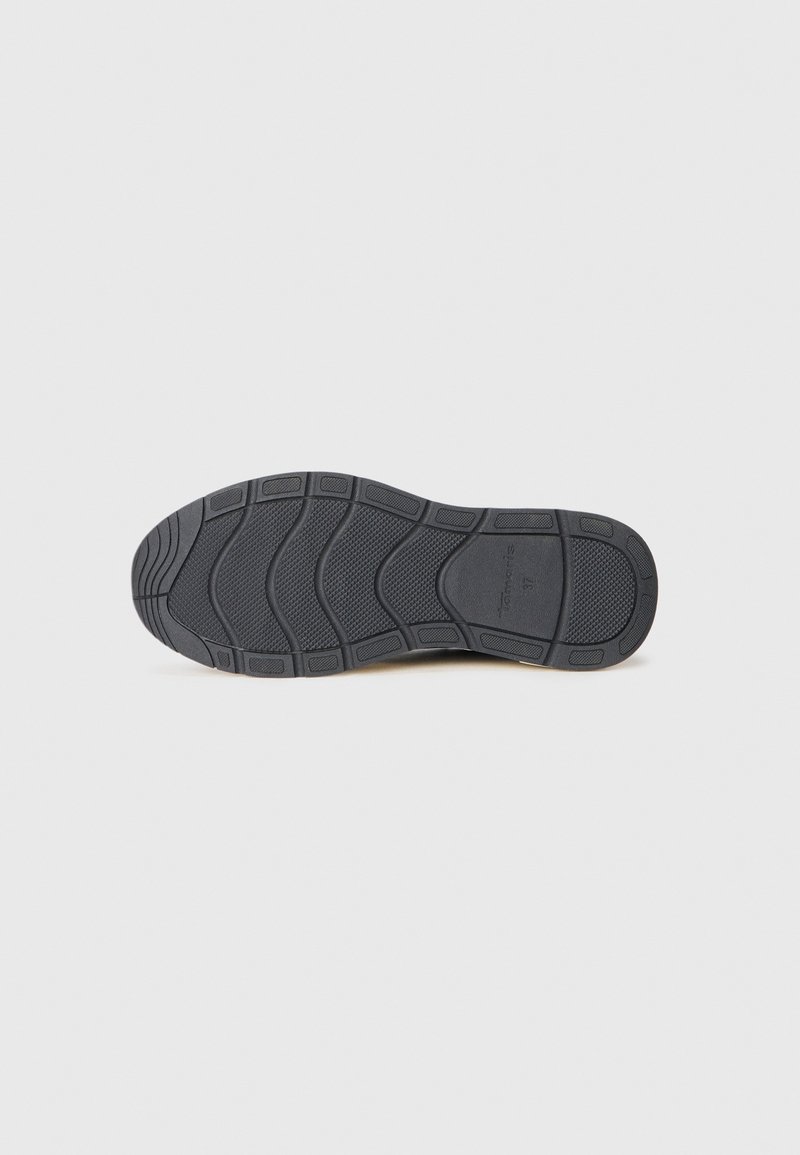 Semelle de chaussure en caoutchouc noir avec une surface texturée, présentant des motifs rainurés pour une meilleure adhérence. Design à bout arrondi et talon courbé.