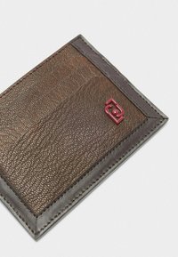 Portafoglio in pelle marrone con finitura testurizzata. Presenta un bordo marrone scuro e un logo in rilievo color bordeaux sulla parte anteriore. Design compatto e rettangolare.
