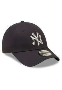 Gorra de béisbol negra con correa ajustable, que presenta un logotipo blanco de los New York Yankees en la parte frontal. El tejido es suave con una ligera textura.