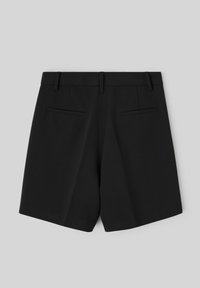 Shorts noirs sur mesure avec un devant plat, deux poches arrière et une texture lisse. Le design présente une coupe nette et une ceinture structurée.