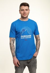Niebieska bawełniana koszulka z grafiką przedstawiającą góry oraz napisem "DURHAM MOUNTAINEERING" w białym kolorze, o jedwabistej fakturze, z krótkim rękawem.