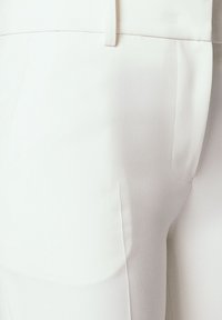 Białe dopasowane spodnie o gładkiej fakturze, smukłej sylwetce, kieszeniach bocznych i płaskim pasie dla eleganckiego wyglądu.