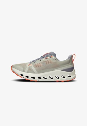 Hellgraue Laufschuh mit einem Obermaterial aus Mesh, akzentuiert durch orange und graue Details, gepolsterte Sohle mit Ausschnitten und einer strukturierten Oberfläche.