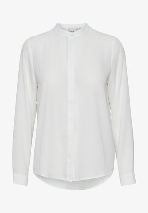 Valge pika varrukaga särk kõrge kaelusega, ees nupuga sulgemine ja kumer allserv. Valmistatud siledast kangast ilma mustriteta.