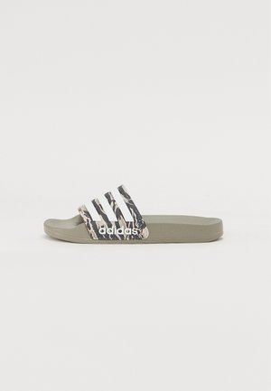 Olíva zöld Adidas papucs, mintás pánttal, fehér három csíkkal és logóval. Puha, rugalmas anyagból készült.