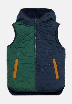 Veste sans manches matelassée avec capuche, présentant des panneaux verts et bleu marine et des poches avant avec bordure marron.