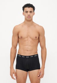 Boxers en coton noir avec une large ceinture élastique de marque. Présente un design ajusté et une texture lisse. Convient pour un usage quotidien.