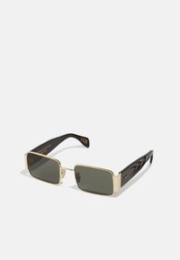 Lunettes de soleil rectangulaires dorées avec des verres vert foncé, présentant des branches noires élégantes avec un motif en vagues. Marquage CE visible sur le côté.
