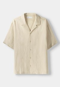 Kortärmad beige skjorta, strukturerad tyg, öppen krage, knäppning fram, med vertikala ränder och avslappnad passform.