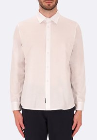 Camicia bianca a maniche lunghe realizzata in tessuto leggero, con colletto button-down e orlo dritto, caratterizzata da una texture e dettagli sottili.