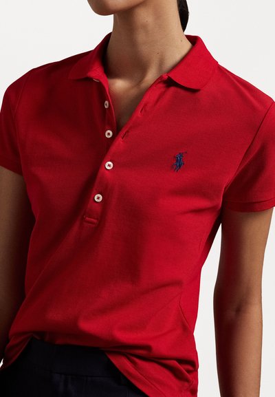 Red polo shirt in cotton fabric, featuring a classic collar, short sleeves, and a small blue embroidered logo on the left chest.