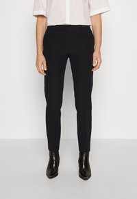 Svarta skräddarsydda byxor med slim fit, tillverkade av slät tyg, med midjeband, bältesöglor och en ren finish. Bärs med ankelstövlar.