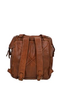Mochila de cuero marrón con dos asas ajustables, una superficie texturizada y cierre de cremallera. Los acentos incluyen un patrón cosido y bolsillos exteriores.