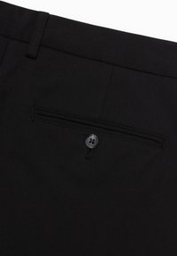 Schwarze Hosen mit glatter Textur, flachem Bund und einer Gesäßtasche mit einem einzigen schwarzen Knopfverschluss.