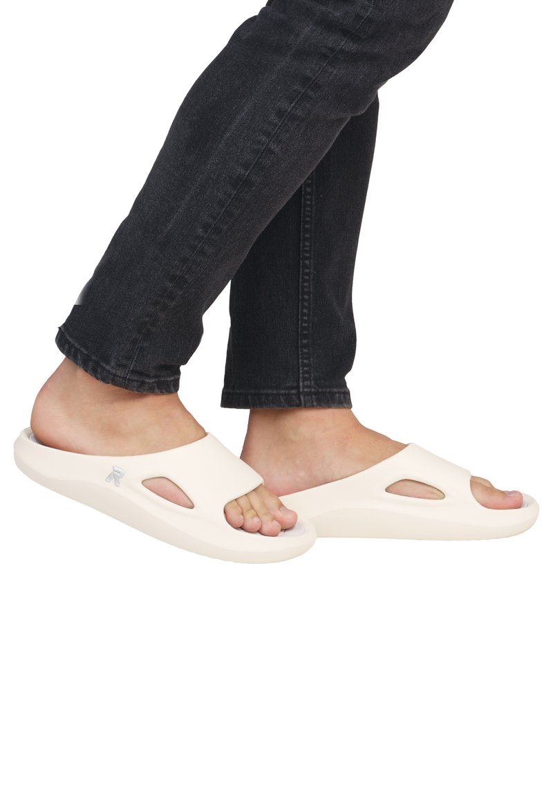 Open-toe slide sandals in beige, made from smooth rubber, featuring cut-out details and a textured sole for grip.