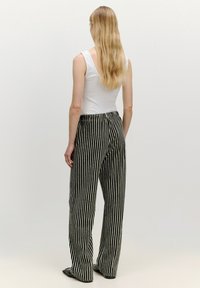 Zwart-witte gestreepte broek met wijde pijpen en een elastische tailleband. Glad textuur en lange broeklengte, geschikt voor casual wear.