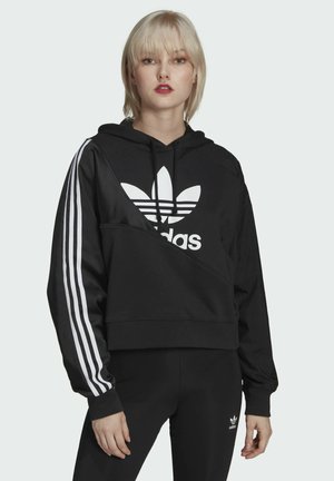Zwarte cropped hoodie met wit Adidas-logo en drie witte strepen op de mouwen. Zachte stof met een relaxte pasvorm en capuchon.