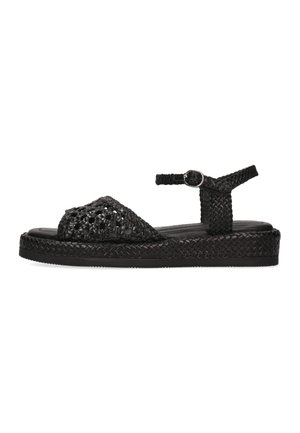 Sort flettet flad sandal med ankelrem og spænde, med flettet sål og åben tå-design.