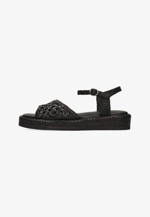 Sort flettet flad sandal med ankelrem og spænde, med flettet sål og åben tå-design.