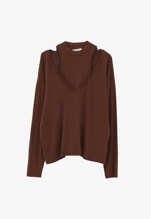 Haut marron à manches longues présentant un design unique en couches avec un col montant court et un profond décolleté en V en dessous, fabriqué en tissu doux et texturé.