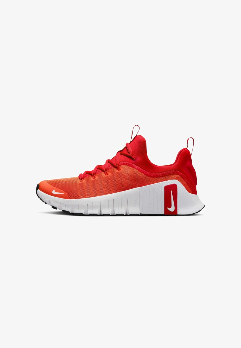 Rode sportschoenen met een gestructureerde bovenkant, vlakke witte zool en zwarte accenten. Kenmerken zijn onder andere opvallende veters en brandmerken op de zijkant.