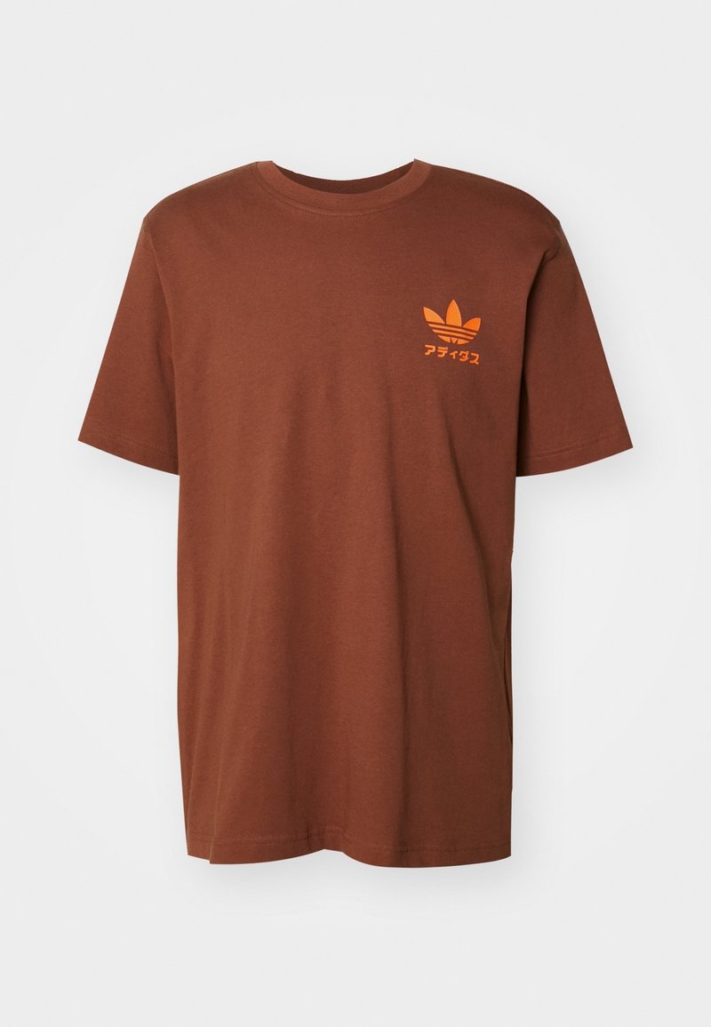 T-shirt di cotone marrone con maniche corte, collo rotondo e logo e testo stampati arancione sul lato sinistro del petto. Texture liscia.