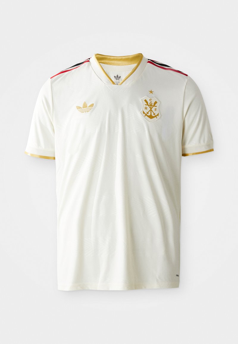 Weißes Fußballtrikot mit V-Ausschnitt, goldenen Akzenten, schwarzen und roten Streifen an den Schultern und einem goldenen Emblem auf der Brust. Weiche, glatte Textur.