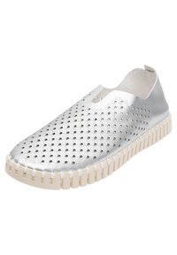Zapato deslizante de color plata metálico con diseño perforado, costados elásticos y suela de goma blanca con estrías horizontales.