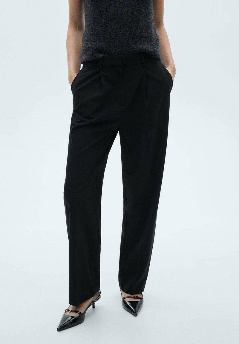 Black tailored trousers with a straight-leg fit, pleated front, and side pockets, complemented by pointed black heels.