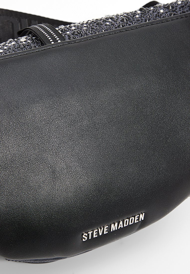 Czarna skórzana torba Steve Madden z srebrnym logo i błyszczącą, teksturowaną górną krawędzią.