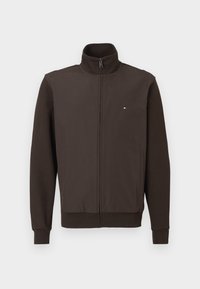 Brūns pilnās jebkurš zips jakas ar stāvo krāgu, sānu kabatām, ribotām aprocēm un apakšmalu, kā arī nelielu sarkanu, baltu un zilu logo uz krūtīm.