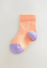 Cotton sock with a ribbed texture, featuring a peach upper and light purple toe and heel accents. Classic crew length design.