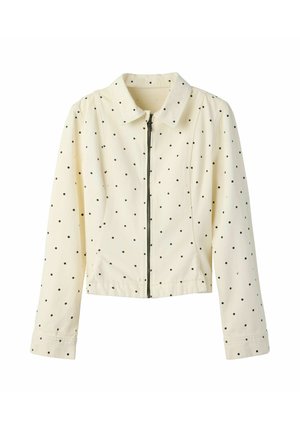 Jachetă de culoarea creme cu buline negre, mâneci lungi, guler și închidere cu fermoar în față, afișată pe fundal alb.