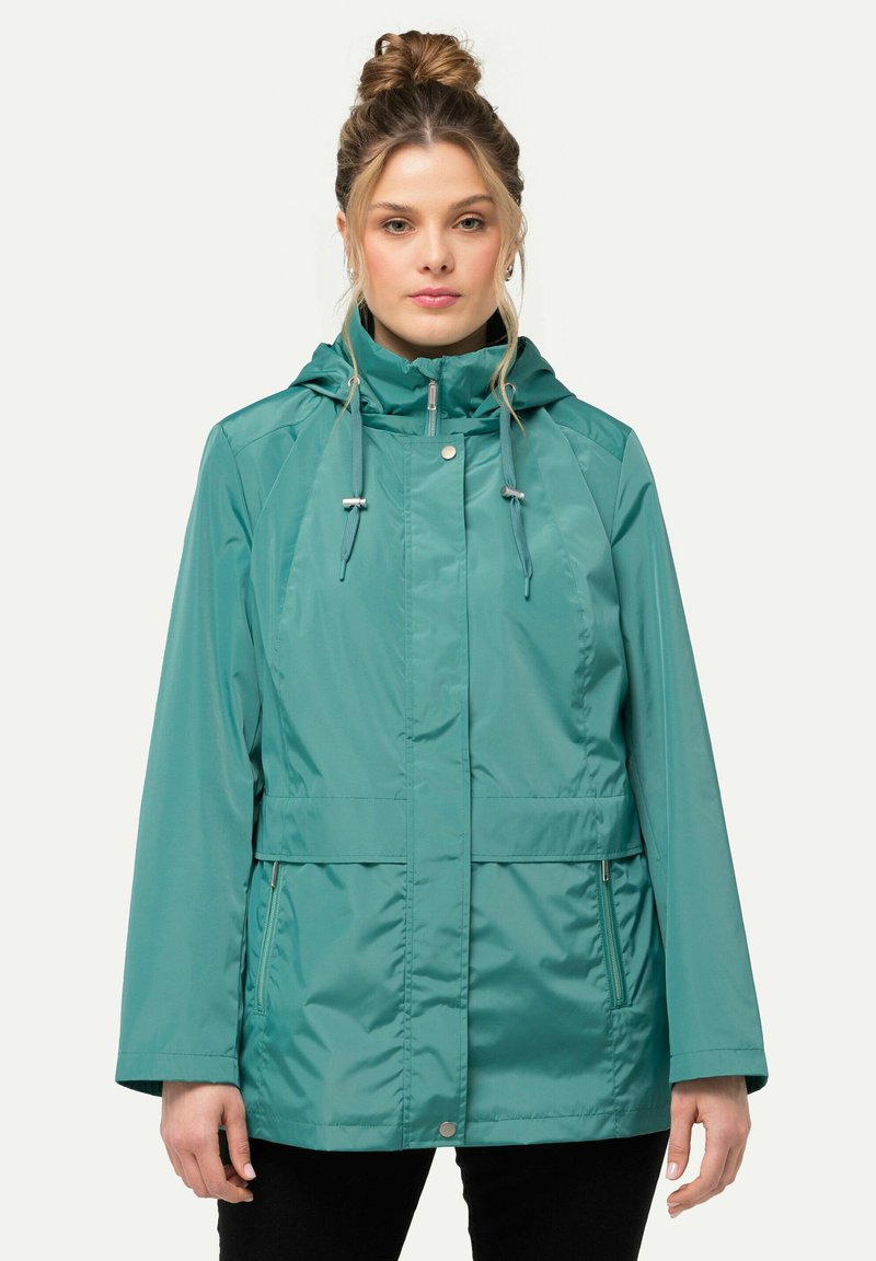 Teal waterdichte jas met een capuchon, ritssluiting, trekkoorden en zijzakken. Heeft een gladde, glanzende buitenkant en een losse pasvorm.