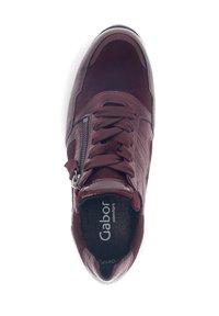 Bordeauxfarbener Sneaker mit einem Design aus verschiedenen Materialien, bestehend aus Wildleder und glattem Leder, rundem Zehenbereich, Schnürsenkeln und seitlichem Reißverschluss. Sichtbares Gabor-Logo.