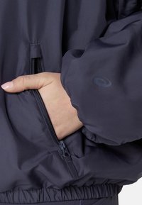 Marineblau bomberjacke mit glatter, matter Oberfläche. Verfügt über eine mit Reißverschluss verschließbare Tasche und elastische Bündchen. Logo-Detail am Ärmel.