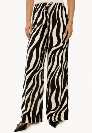 Pantalons larges à rayures zébrées noir et blanc avec une taille élastique et un cordon de serrage, fabriqués à partir d'un tissu léger.