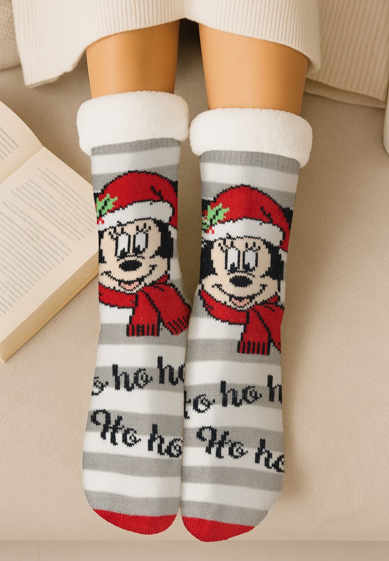 Calzini a righe rosse e grigie con un grande volto di cartone animato, che somiglia a un personaggio che indossa un berretto e una sciarpa rossi, con una soffice fascia bianca e un design testuale.