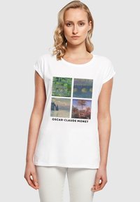Valkoinen puuvillapaita, jossa on neljän Monet-taideteoksen printtiä ruudukossa. Lyhyet hihat, pyöreä pääntie ja musta teksti "OSCAR-CLAUDE MONET."
