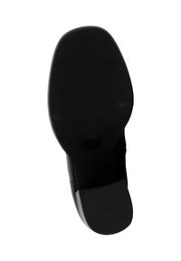 Suola di scarpa nera con un design liscio e arrotondato. Presenta una superficie in gomma testurizzata per una buona presa e una leggera curvatura nel tallone per maggiore stabilità.