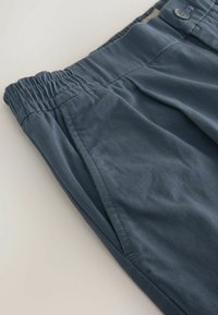 Dunkelblaue Baumwollhosen mit elastischem Bund, Seitentaschen und glatter Textur mit dezentem Glanz.