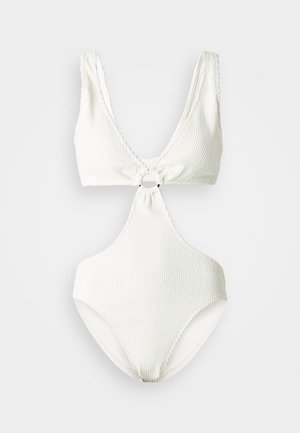 Bijela, teksturirana jednodijelna kupaća kostim s dubokim V izrezom, središnjim vezivanjem i kružnim detaljem. Glatka tkanina i visoko rezani otvor za noge.