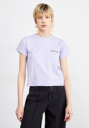 T-shirt en coton violet clair avec un col rond, des manches courtes et un petit logo noir sur la poitrine gauche. Design cropped avec une coupe décontractée.