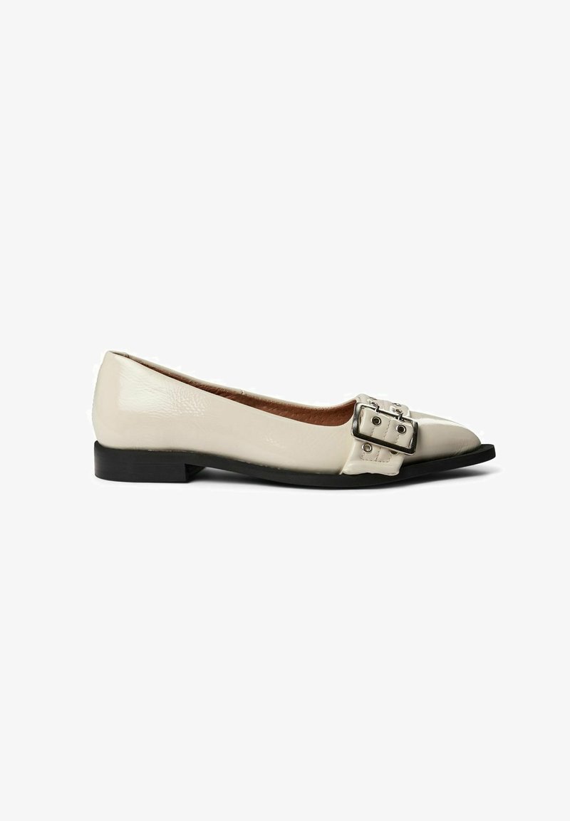 Beige patent leather ballet flats with a pointed toe, featuring a metallic double buckle detail and a low black rubber sole.