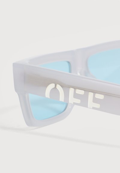 Lunettes de soleil blanches translucides avec des verres bleu clair et le mot « OFF » en lettres blanches sur la branche.